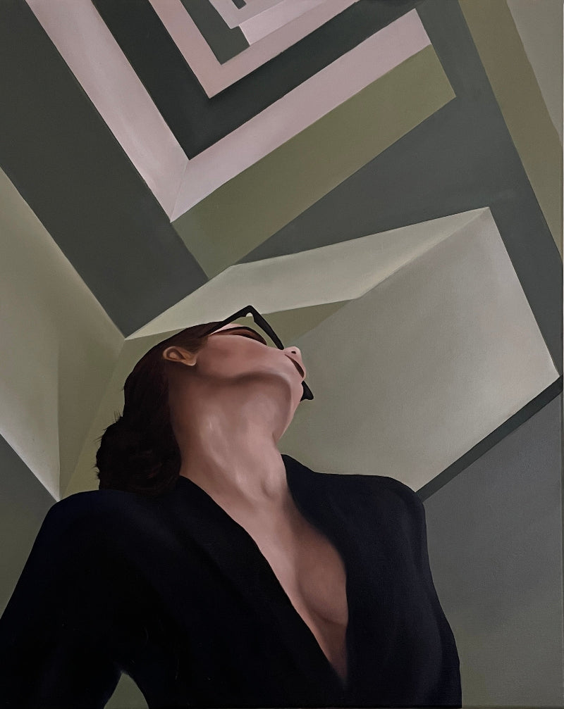 Woman wearing glasses looking up at a geometric wall design